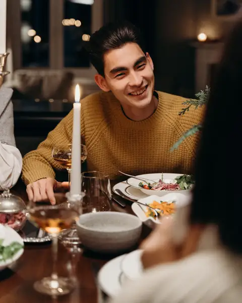 A man smiling across a candlelit dinner table