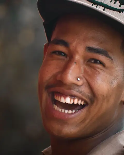 A man in a cap laughing outdoors