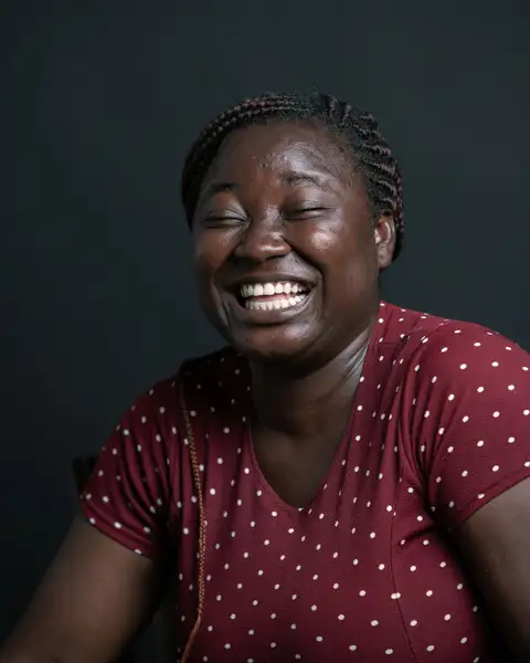 A woman in a polka dot shirt laughing